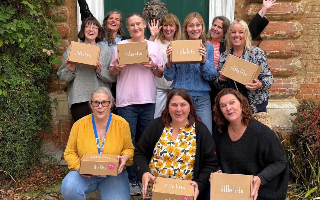 Members of the community holding Little Lifts Boxes at Breast Cancer Charity Community Packing Party in October