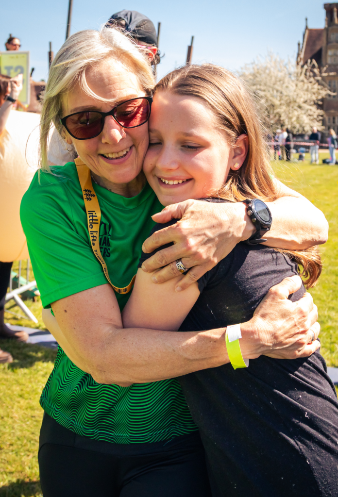 Breast cancer charity beneficiary and runner hugging family