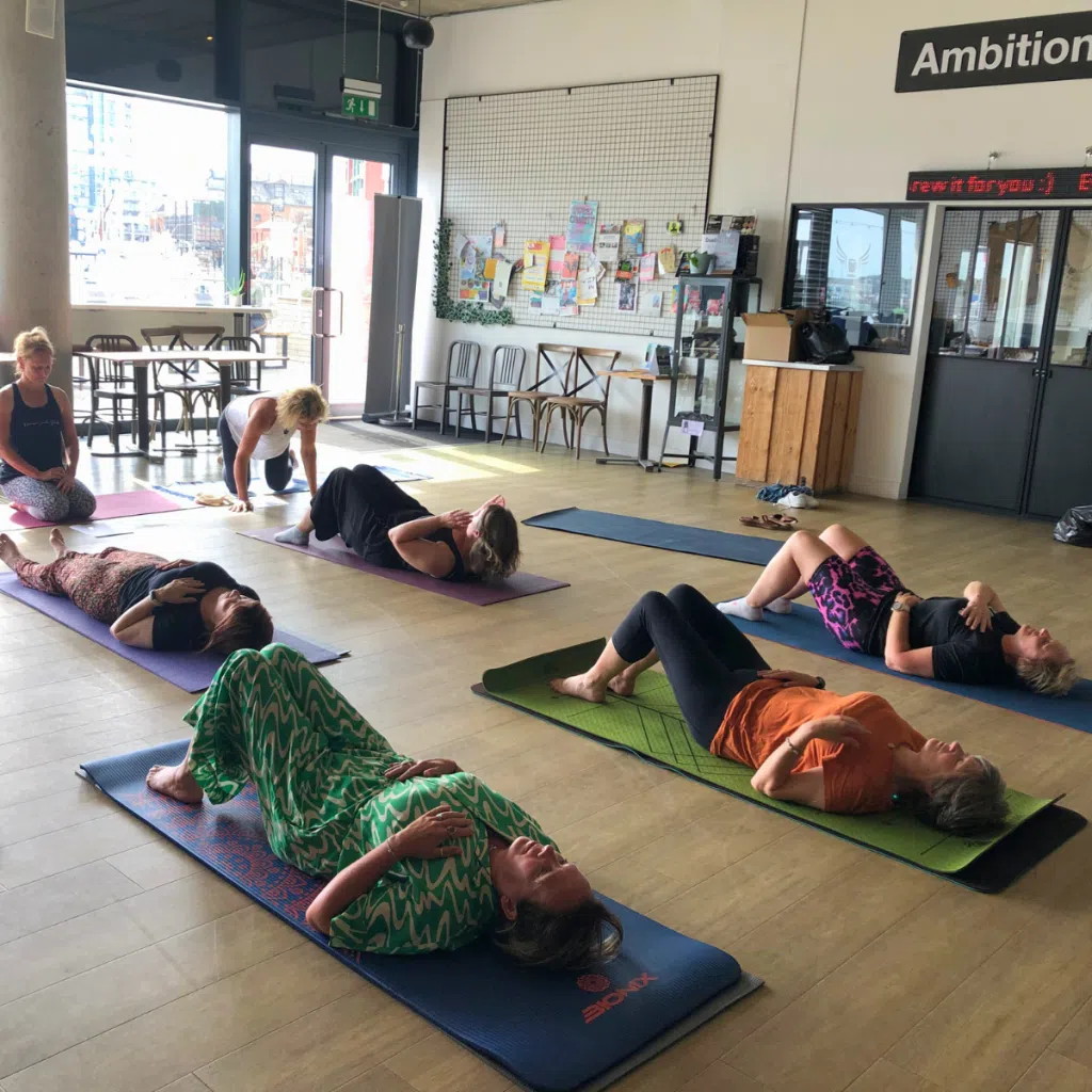People affected by breast cancer at a community club event doing yoga