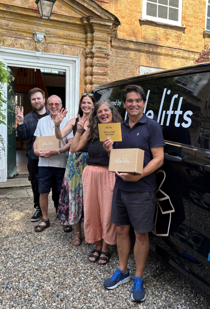 George Diggle with the Little Lifts team, holding gift Boxes outside the charity's HQ