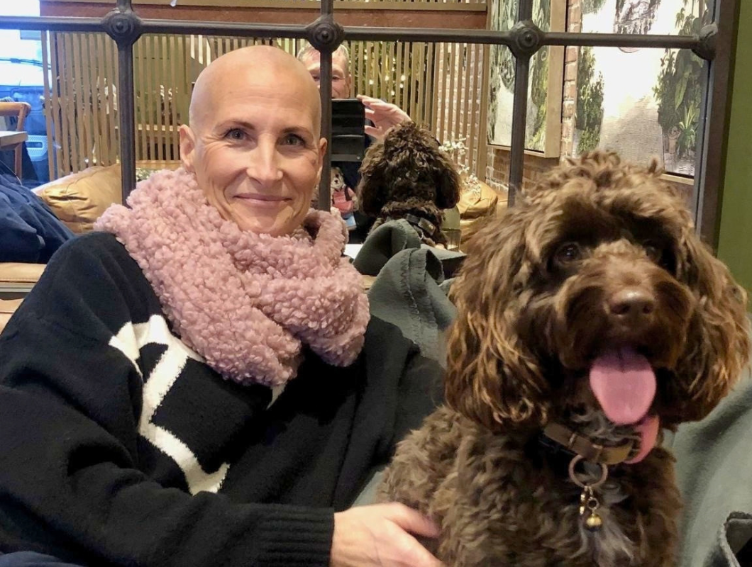 Hannah smiling with her dog while receiving treatment for breast cancer
