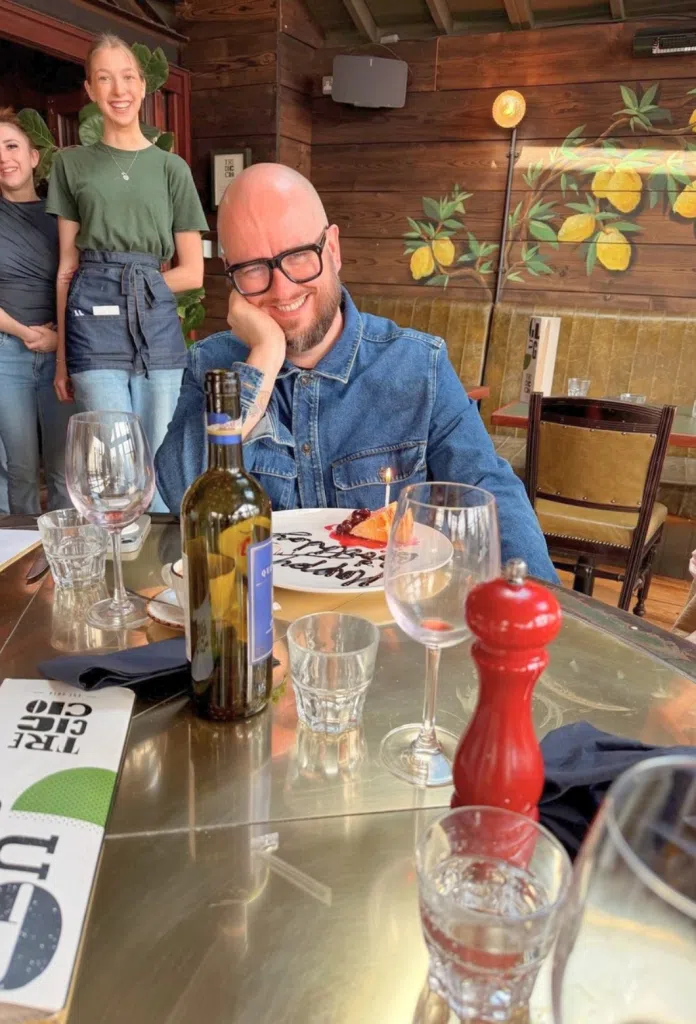James smiling enjoying a meal out in a restaurant