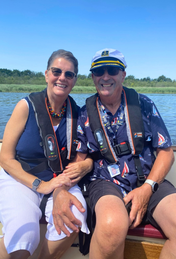 Two Little Lifts community members smiling together during their Norfolk Broads boat trip