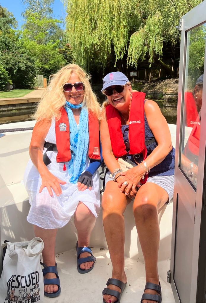 Two Little Lifts community members laughing together on their Norfolk Broads boat trip