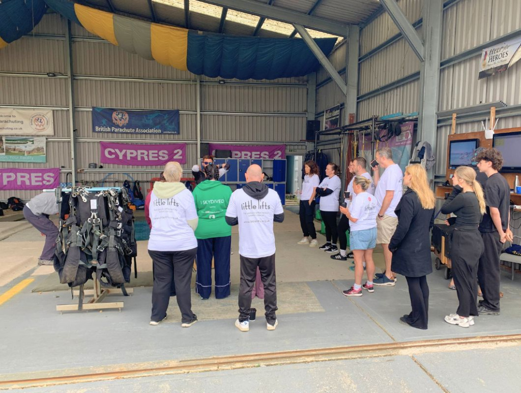 Little Lifts breast cancer charity skydivers listening to a safety briefing wearing Little Lifts and "I skydived" branded tops ahead of their charity jump.